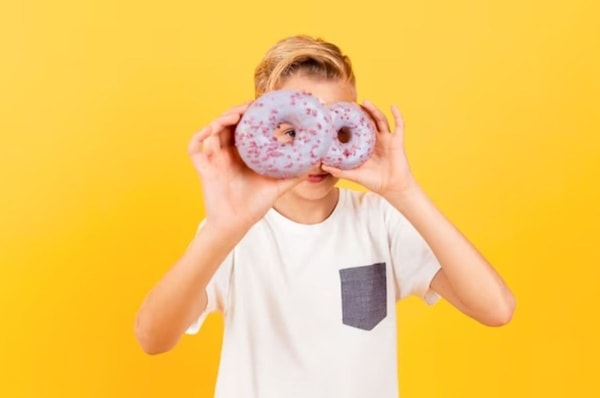 kid posing with donuts