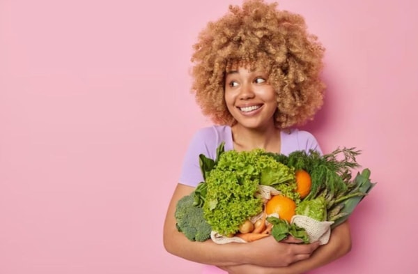 woman holding vegetables and fruits