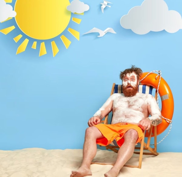 man with spf 50 all over his body on the beach