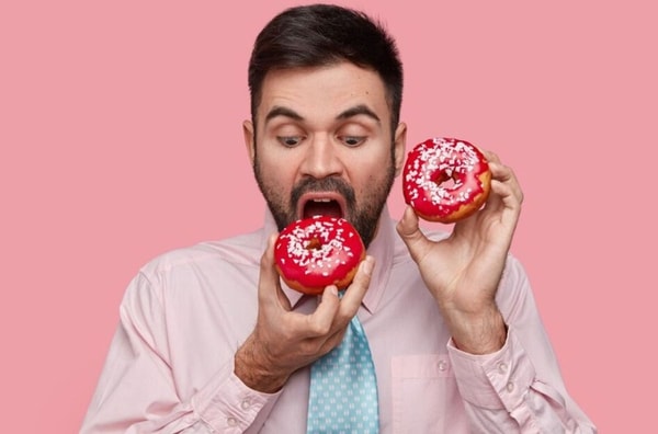 man eating pink donut