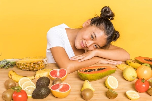 woman posing with fruits and vegetables